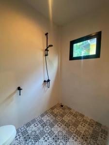 een badkamer met een toilet en een raam in de muur bij Green & Pink Garden Homes in Ko Phangan