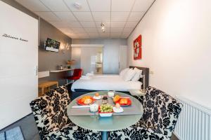 ein Hotelzimmer mit einem Bett und einem Tisch mit Essen darauf in der Unterkunft B&B Groene Meent in Leerdam