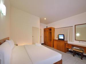 a bedroom with a large white bed and a television at Krabi Grand Place Hotel in Ban Khlong Chi Lat