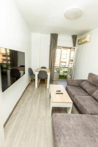 Apartament with balcony في مدريد: غرفة معيشة بها أريكة وطاولة