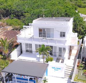 an overhead view of a white house with palm trees at 全室オーシャンビュー外階段付き一棟貸切プライベートヴィラ in Kouri