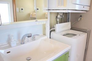 a bathroom with a toilet and a sink at 全室オーシャンビュー外階段付き一棟貸切プライベートヴィラ in Kouri +43 photos