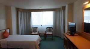 une chambre d'hôtel avec un lit et une télévision dans l'établissement The Majestic Sakon Nakhon Hotel, à Sakon Nakhon