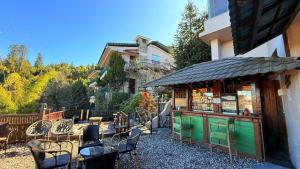 ChambaThe Terraces - Kanatal的一家餐厅，旁边有一张桌子和几把椅子，旁边是一栋建筑物。