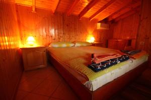 1 dormitorio con 1 cama en una habitación de madera en Guest House Nash Dom, en Kavarna