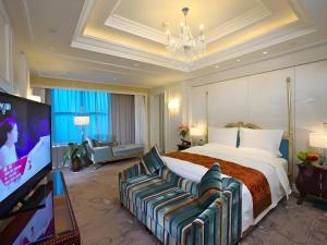 Una habitación de hotel con una cama grande y un televisor de pantalla plana. en Yuncheng Jianguo Hotel, en Yuncheng