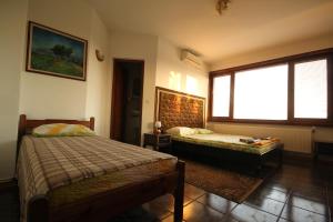 a bedroom with two beds and a large window at Guest House Nash Dom in Kavarna