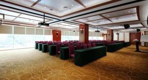 Una gran sala con sillas y mesas rojas. en Grand Nest Hotel (Tang Jia Wan Beach), en Tongka