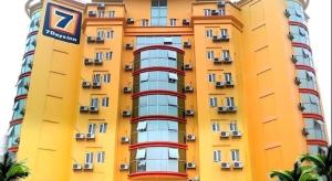 a yellow building with red windows and a sign on it at 7 Days Inn Shantou Chenghai in Batou