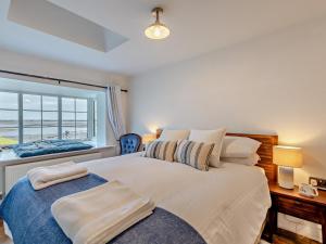 a bedroom with a large bed with a window at 2 Bed in Ravenglass 95884 in Ravenglass