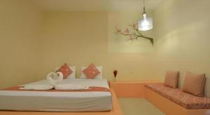 ein Schlafzimmer mit einem Bett und einer Couch darin in der Unterkunft Mittraphap Resort in Ban Sathani Bandai Ma