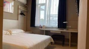 Ένα ή περισσότερα κρεβάτια σε δωμάτιο στο Jinjiang Inn Wuhan Huanghelou Fuxing Road Metro Station