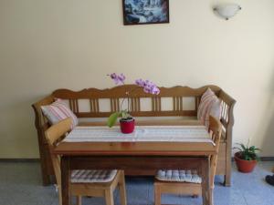 a wooden table with a flower vase on it at Pensiunea Arpasel in Arpaşu de Sus