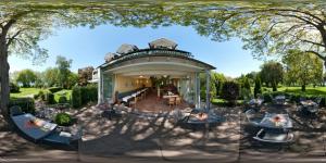 una casa con un cenador con sillas y mesas en Iris am See garni, en Radolfzell am Bodensee