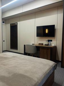 pokój hotelowy z łóżkiem, biurkiem i telewizorem w obiekcie NOMAD Self Check in Hotel w mieście Zhezdi