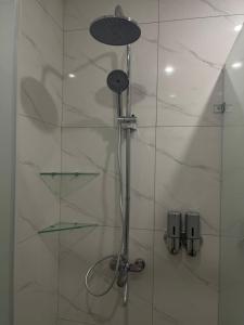 prysznic z głowicą prysznicową w łazience w obiekcie NOMAD Self Check in Hotel w mieście Zhezdi