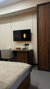 pokój hotelowy z łóżkiem i telewizorem z płaskim ekranem w obiekcie NOMAD Self Check in Hotel w mieście Zhezdi