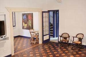 - un salon avec des chaises, une table et une télévision dans l'établissement Farfalla Guest House, à Rio de Janeiro