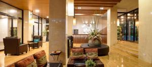 a lobby with a couch and chairs in a building at The Loft Seaside Sriracha Hotel in Si Racha