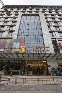 a tall building with a large building with windows at Jinjiang Metropolo Hotel - Ningde Wanda Plaza in Ningde