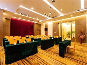 a conference room with tables and chairs and a red curtain at Jinjiang Metropolo Hotel - Ningde Wanda Plaza in Ningde