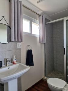 a bathroom with a sink and a shower and a toilet at Casa 14 Zimilene Xai Xai in Xai-Xai