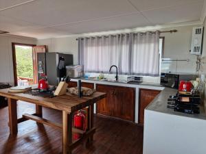 a kitchen with a wooden table and a counter top at Casa 14 Zimilene Xai Xai in Xai-Xai