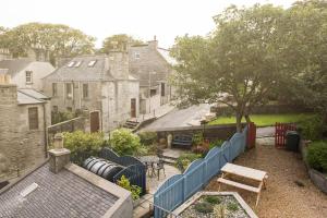 a backyard with a blue fence and a wooden bench at Fort Charlotte in Lerwick