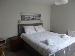 Un dormitorio con una cama con sábanas y almohadas blancas. en Zilvermeeuw - Drieplassenweg, en Katwijk