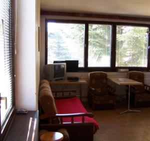 Robotnícka ubytovňa Bodice 104 في ليبتوفسكي ميكولاش: غرفة معيشة مع أريكة ومكتب مع جهاز كمبيوتر