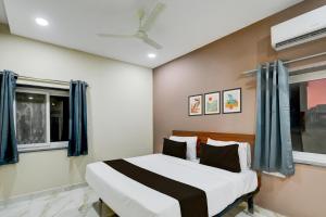 a bedroom with a large bed with blue curtains at Hotel O PRIME HUB in Lingampalli