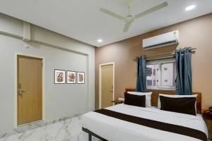 Un dormitorio con una cama y un ventilador de techo. en Hotel O PRIME HUB, en Lingampalli