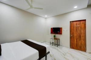 Un dormitorio con una cama y una puerta de madera. en Hotel O PRIME HUB, en Lingampalli