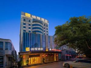 un grand bâtiment avec des fenêtres dans une ville dans l'établissement Echeng Hotel Qinzhou Bay Plaza East High-speed Railway Station, à Qinzhou