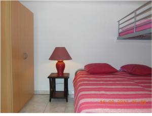 a red lamp on a table next to a bed at Un coin de campagne en ville in Le Cannet