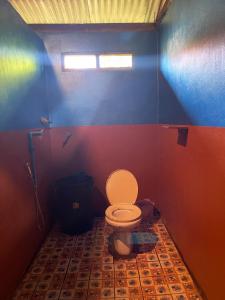 Un baño con inodoro y una pared de color arcoíris. en Tina's Homestay-Tadlo, en Tad Lo 38 fotos más