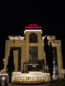 un hotel con un gran edificio con un cartel en TIRUPATI WHITE - Hotel & Restaurant, en Kekri