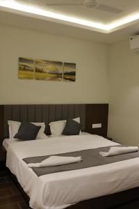 Un dormitorio con una gran cama blanca con dos cuadros en la pared. en TIRUPATI WHITE - Hotel & Restaurant, en Kekri 4 fotos más