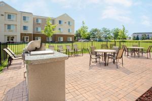a patio with tables and chairs and a fountain at Baymont by Wyndham Green Bay in Green Bay
