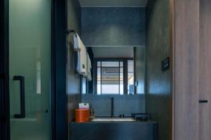 a bathroom with a sink and a mirror at Dayucang Tea Sea Cloud Inn Jingmai Ancient Tree Tea Forest Store in Mengzhe +45 photos