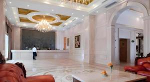 uma sala de estar com um lustre e um homem de pé no átrio em Vienna Hotel Shenzhen Bao'an Airport Taoyuanju Pingluanshan Metro Station em Xin'an