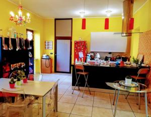 a kitchen with a counter and tables and chairs at Oasi di Frattamaggiore in Frattamaggiore +2 photos
