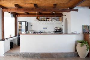 a bar in a white room with a wooden ceiling at Hotel Santa Marina Antica Foresteria in Santa Marina Salina