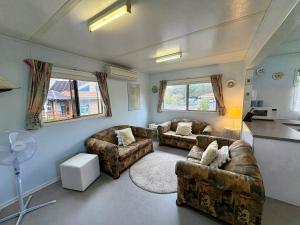 un soggiorno con due divani e una cucina di Cosy Corner Cabin a Broadwater