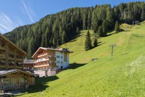 budynek na zboczu zielonego wzgórza w obiekcie Giardin Boutique Hotel B&B w mieście Selva di Val Gardena