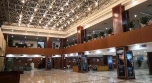 a large building with a lobby with a lot of plants at Yichang Three Gorges Project Hotel in Yichang