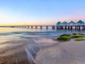 una spiaggia con un molo con case nell'acqua di Cosy Corner Cabin a Broadwater