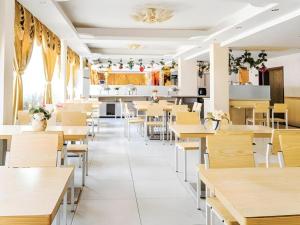 an empty restaurant with tables and chairs at Jian Guo Grand Hotel in Ban Dông-Naxôk