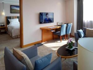 ein Hotelzimmer mit einem Schreibtisch und einem Schlafzimmer in der Unterkunft GreenTree Eastern Bijie Qixingguan Zhaoshanghuayuan Hotel in Bijie