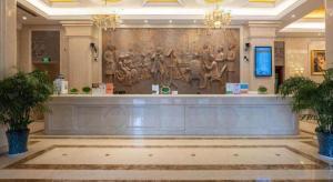 Un vestíbulo con una pared con estatuas. en Vienna International Shanghai Nanxiang, en Chenjiahang